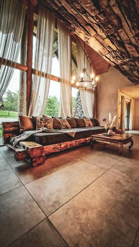 a living room with a large couch and a large window at Koča na samem Prestiž in Šalovci