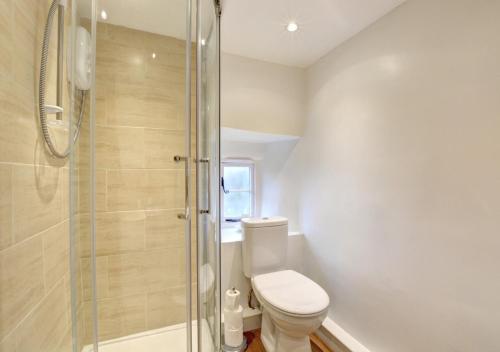 a bathroom with a toilet and a glass shower at Lukes House in Askrigg
