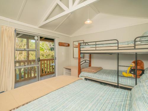 a bedroom with two bunk beds and a window at Hahei Horizon - Hahei Holiday Home in Hahei