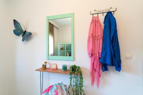 a mirror hanging on a wall next to a shelf at Villa Iasama in Rhodes Town