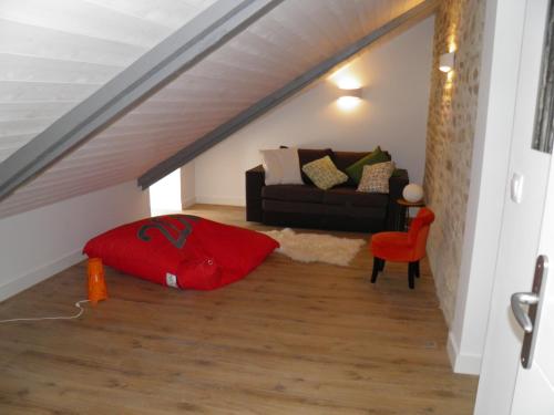 a living room with a couch and a red chair at Manoir des Eperviers in Quéven