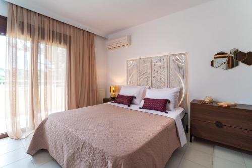 a bedroom with a large bed and a large window at Villa Iasama in Rhodes Town