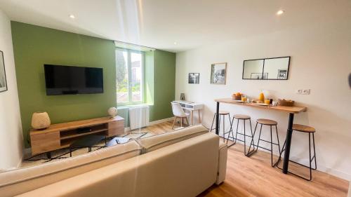 - un salon avec un canapé, une télévision et un bar dans l'établissement Le Vert’ueux - Appartement tout équipé à Niort, à Niort