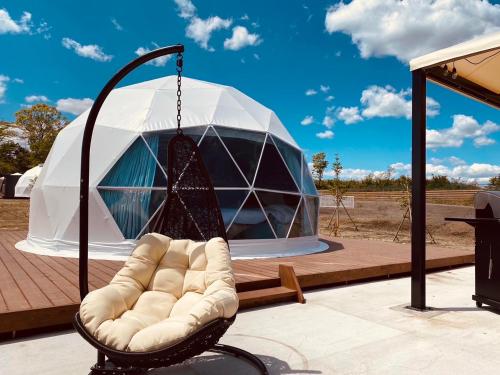 a swinging chair on a patio with a dome at chillout glamping zao in Zao