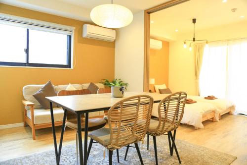 - une salle à manger avec une table, des chaises et un lit dans l'établissement GrandTree Hotel - Specutaclor Skytree view!, à Tokyo