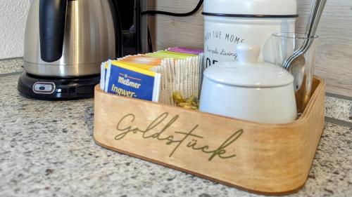 a wooden holder with a candle and books on a counter at FeWo Goldstück mit privatem SPA und Whirlpool in Grafenau