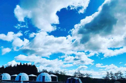 a group of tents under a cloudy sky at chillout glamping zao in Zao