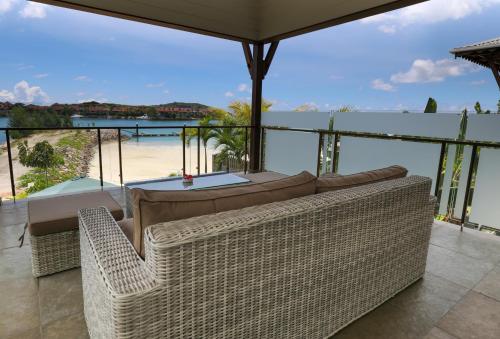 JA Enchanted Waterfront Seychelles في ماهي: غرفة معيشة مع أريكة وإطلالة على الشاطئ