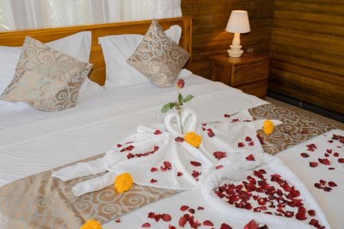 a bed with white towels and flowers on it at ABIAN HOUSE NUSA PENIDA in Batununggul