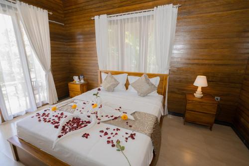 a bedroom with a bed with flowers on it at ABIAN HOUSE NUSA PENIDA in Batununggul