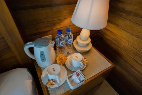 a table with a lamp and water bottles on it at ABIAN HOUSE NUSA PENIDA in Batununggul