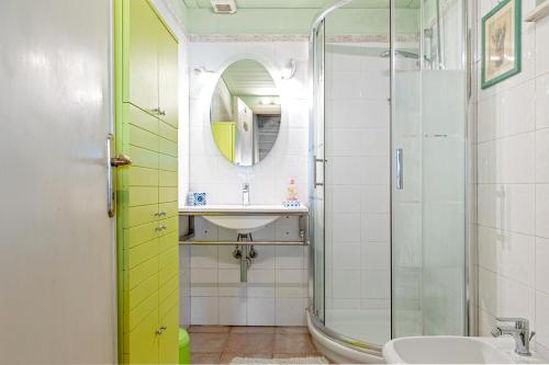 bagno con lavandino e doccia in vetro di Piccola casa immersa nel verde a Quercianella