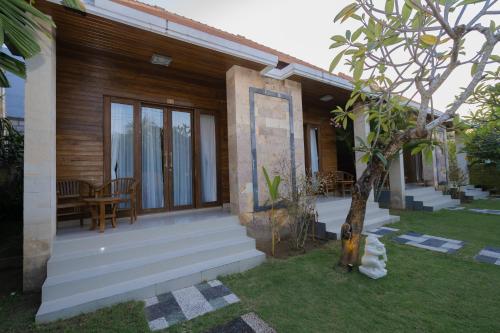 a house with a porch with a table and chairs at ABIAN HOUSE NUSA PENIDA in Batununggul