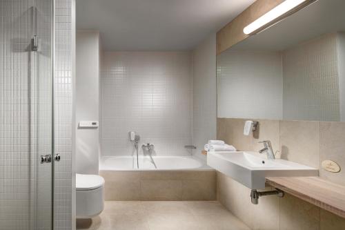 La salle de bains est pourvue d'une baignoire, d'un lavabo et de toilettes. dans l'établissement Quality Hotel Ostrava City, à Ostrava