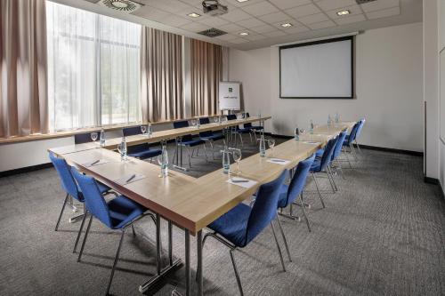 a conference room with long tables and blue chairs at Quality Hotel Ostrava City in Ostrava