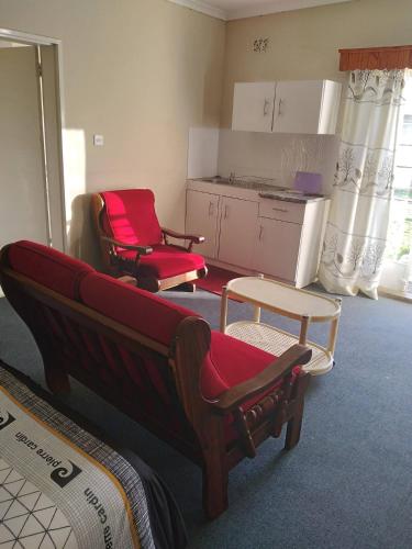 a living room with two chairs and a kitchen at Neat guest suite with office corner - 2101 in Harare