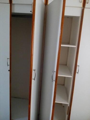 un armario con 2 estanterías blancas y un espejo en Neat guest suite with office corner - 2101 en Harare