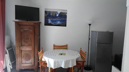 une salle à manger avec une table et une télévision dans l'établissement STUDIO TERRASSE JARDIN VANNES, proximité port et centre historique, parking privé, à Vannes