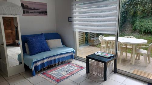 un salon avec un canapé, une table et une fenêtre dans l'établissement STUDIO TERRASSE JARDIN VANNES, proximité port et centre historique, parking privé, à Vannes