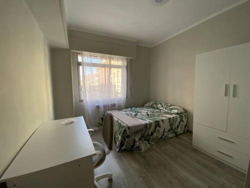 a small bedroom with a bed and a window at Apartamento acogedor en Logroño in Logroño
