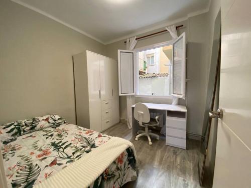 Apartamento acogedor en Logroño في لوغرونيو: غرفة نوم بسرير ومكتب ونافذة