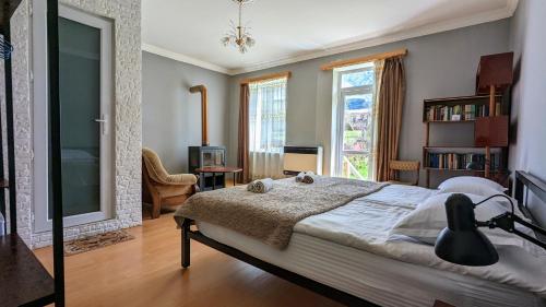 a bedroom with a bed and a large window at Kazbegi Green Yard in Stepantsminda