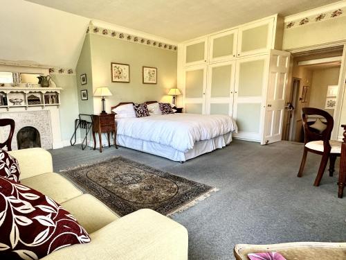 a bedroom with a bed and a fireplace at Farthings Country House Hotel & Restaurant Tunton in Taunton