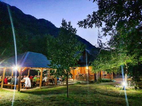 a group of people sitting outside of a building at Rafting Camp Modra Rijeka in &Scaron;ćepan-Polje