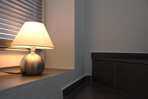 a lamp sitting on a table next to a window at Ferienhaus Meerbude in Südbrookmerland