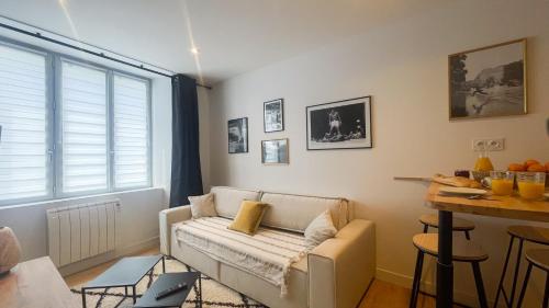 ein Wohnzimmer mit einem Sofa und einem Tisch in der Unterkunft Le Noir’issime - Appartement tout équipé à Niort in Niort