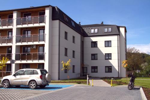 a car parked in a parking lot in front of a building at Apartamenty Lesko 23 in Lesko