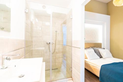 a bathroom with a shower and a bed at Spacious Luxury apartment at the heart of Budapest in Budapest