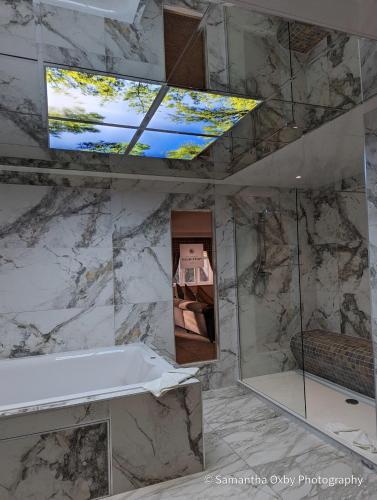 a bathroom with a tub and a tv on a wall at Best Western Premier Doncaster Mount Pleasant Hotel in Doncaster