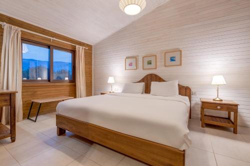 a bedroom with a large white bed and a window at TurkuazKöy in Finike