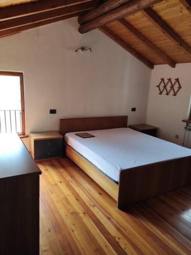 una camera con un grande letto in una stanza con pavimenti in legno di Residenza Campagnano a Musignano