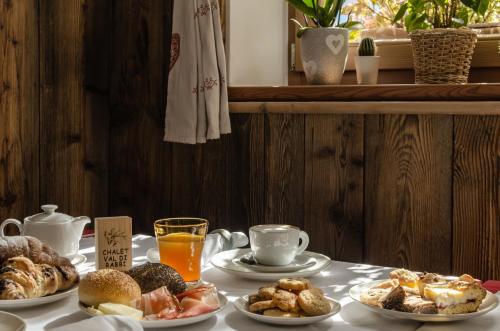 a table topped with plates of breakfast foods and orange juice at Hotel Chalet val di Rabbi in Rabbi