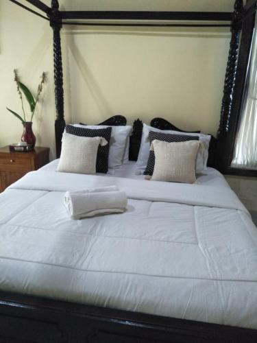 a large bed with white sheets and pillows at Maruan Sari in Ubud