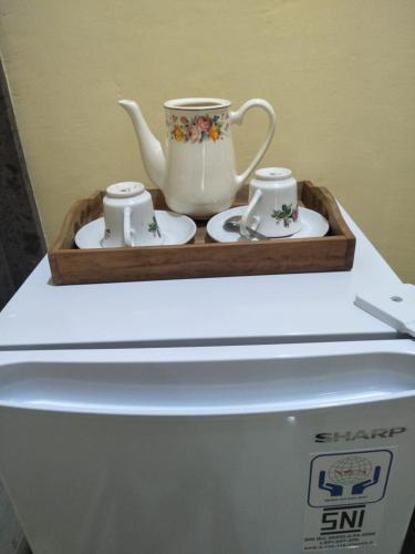 a tray with a tea set on top of a washing machine at Maruan Sari in Ubud