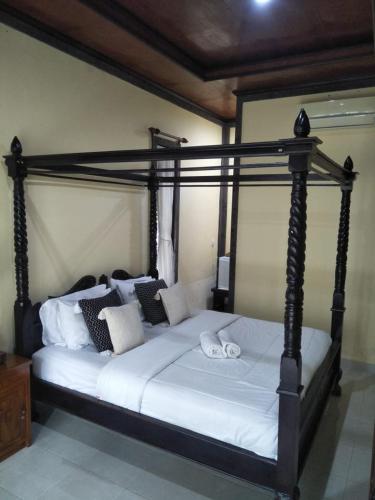 a bedroom with a large bed with white sheets and pillows at Maruan Sari in Ubud