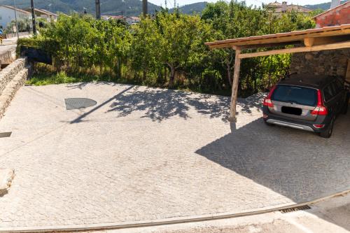 a car parked in a parking lot with a wooden roof at Casa dos Copos - Drinks House in Miranda do Corvo