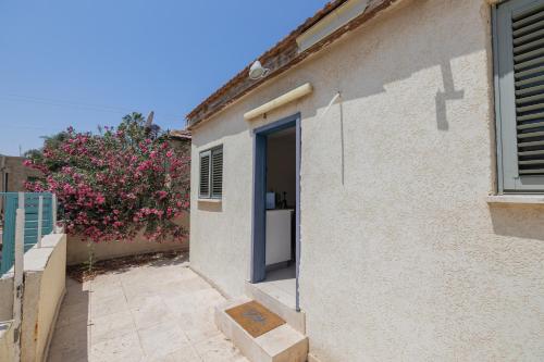 a door to a house with a flowering bush at Shifra Suite in Beer Sheva