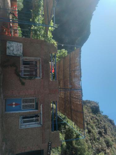 a building with windows on the side of a mountain at Le pont de Dieu in Akchour