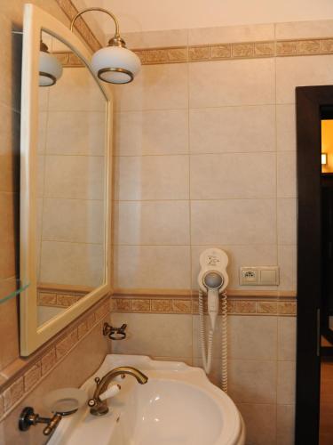 a bathroom with a sink and a mirror at Penzion Kiska Kežmarok in Kežmarok