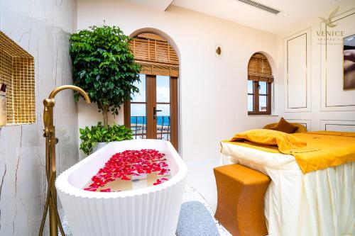 a bathroom with a bath tub filled with red flowers at Roma Hotel Phu Quoc - Free Hon Thom Island Waterpark Cable Car in Phu Quoc