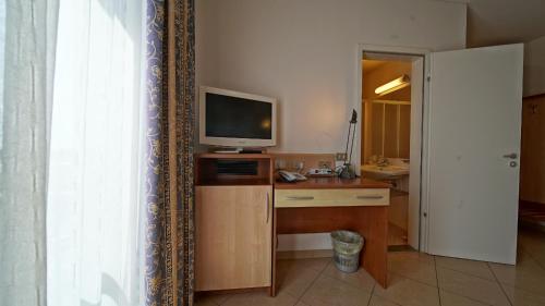 a room with a desk with a television and a deskictericter at Hotel Nuovo Sole HNS in Bovolone