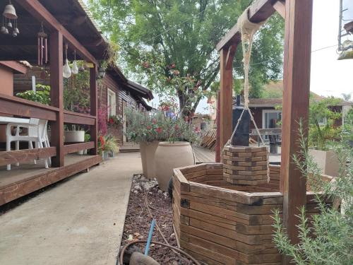 a garden with a pavilion with flowers and plants at שירת דבורה - אירוח משפחתי כפרי in H̱ever