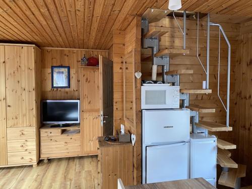 a kitchen with wooden walls and a refrigerator and stairs at Ferienhaus mit direktem Wasserzugang in Berlin-Köpenick in Berlin