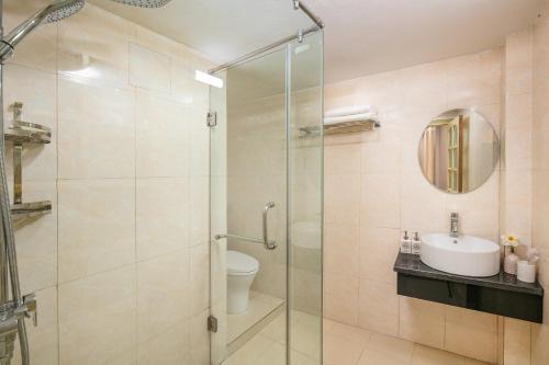 a bathroom with a glass shower and a sink at La Renta Center Hotel & Spa in Hanoi