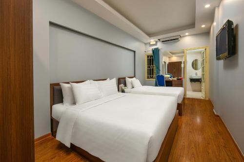 a bedroom with two white beds in a room at La Renta Center Hotel & Spa in Hanoi