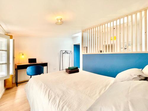 1 dormitorio con cama blanca y pared azul en Niort - Hyper-Centre - Appartements en Duplex ou Triplex - Wifi Fibre - NOUVEAU, en Niort